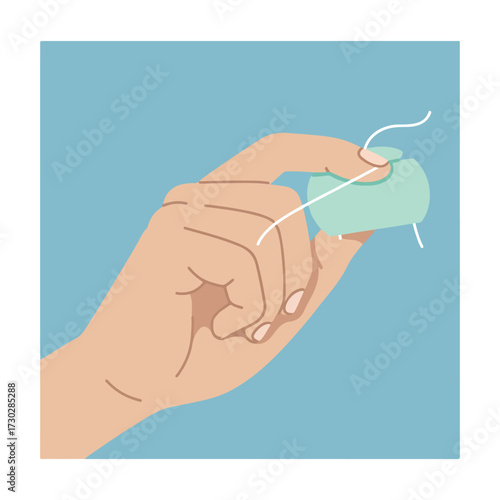 Hand pulls dental floss from a teal dispenser, against light blue background