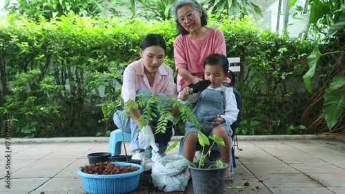 Family planting trees in their home recreational activities, family with young children mother and grandmother working together plant saplings make the home shady and pleasant with green environment.