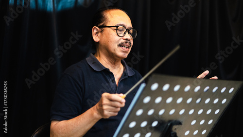 Orchestra Conductor Leading with Baton in rehearsal studio