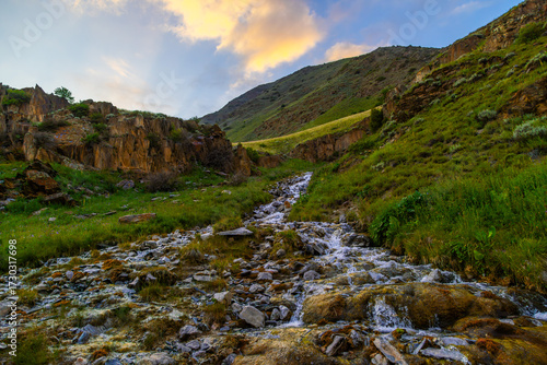 Serene stream flowing through rocky mountainous region in Kyrgyzstan