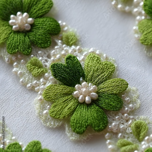 Delicate green embroidered flowers with pearl accents on white lace