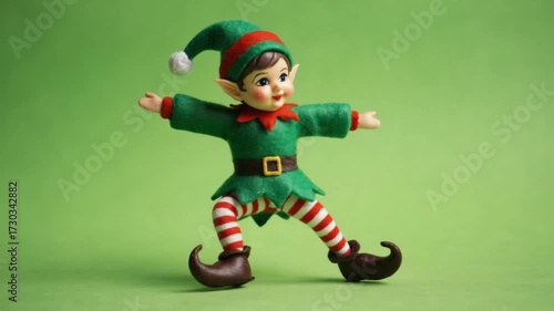 Elf figurine with green and red outfit standing on a green background with arms outstretched christmas elves green screen video