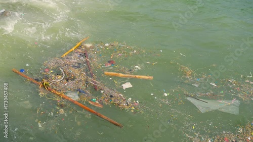 Garbage floating on the beach and in the sea, showing ocean pollution, plastic waste, and environmental problem affecting marine life and ecosystem.