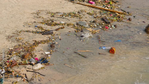Garbage floating on the beach and in the sea, showing ocean pollution, plastic waste, and environmental problem affecting marine life and ecosystem.