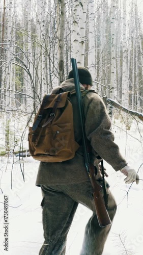 Wallpaper Mural A hunter with a gun walks through the winter forest, tracking wild animals. Hunting animals is a way of human life. Vertical video. Torontodigital.ca
