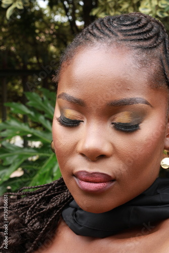 Beautiful African Black Woman with gold earrings  and makeup with braided hair