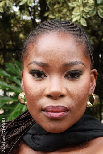 Beautiful African Black Woman with gold earrings  and makeup with braided hair