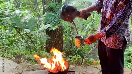 Traditional Indonesian coffee served with hot burning claypot in a cafe in the middle of the pine forest. Food show performances