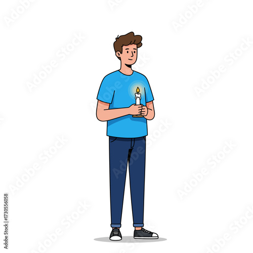 A young man in a blue t-shirt and jeans holds a lit candle, illuminating his thoughtful expression