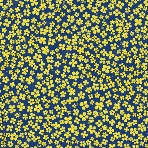 A dense pattern of small yellow flowers scattered across a deep blue background.