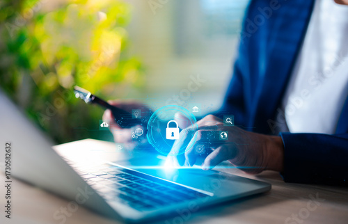 Hand of a man using mobile phone and laptop, secure access to user personal information, secure Internet access, information security encryption. Cybersecurity internet network data privacy concepts.