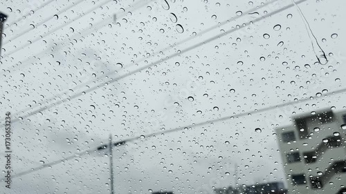 窓ガラスに残る雨粒と街並みのぼんやりした風景