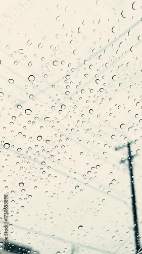 窓ガラスに残る雨粒と街並みのぼんやりした風景