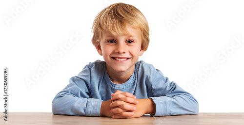 cute, smiling boy sitting at a table, isolated on a transparent background.
