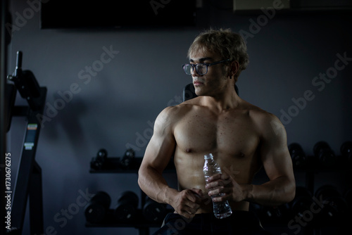 Athletic shirtless handsome young man, muscular young men are exercising with weights in a gym.
