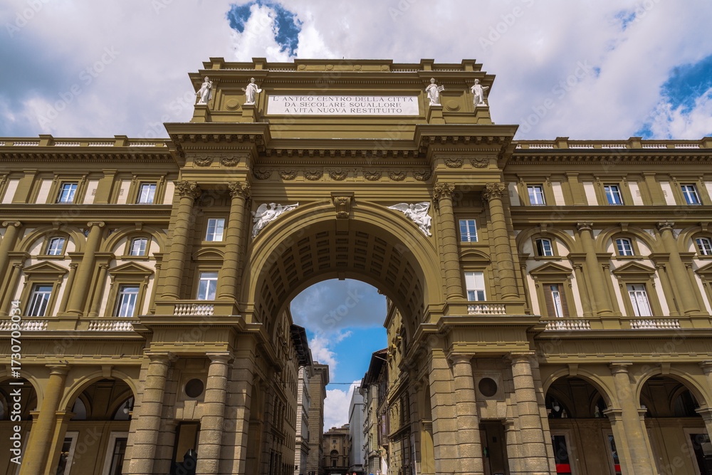 Obraz premium Triumphal arch in an urban setting with architectural elements. Building facade adorned with statues and intricate designs.