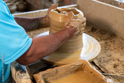 Close-up of the hands of a potter craftsman creating a clay vessel in the traditional way