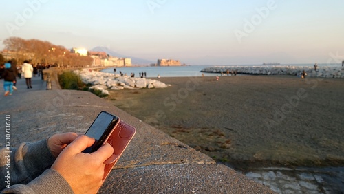 Relaxing with my cell phone in hand on the Naples seafront as the sunset light.
