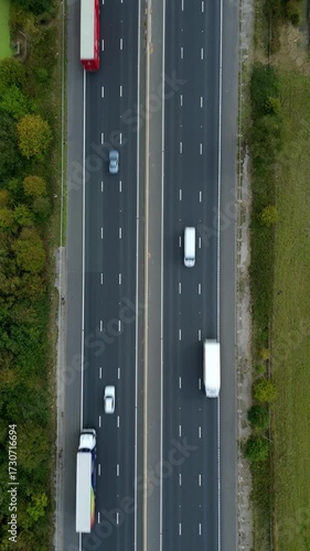 Drone aerial perspective of busy motorway highway with traffic, two lanes, England UK transportation of cars and goods by trucks, road infrastructure 