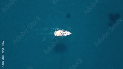 Bateau solitaire en mouvement filmé en vue verticale par drone