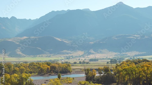 Yellowstone River Anglers in Autumn trees below Towering Mountains