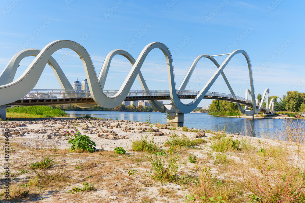 Fototapeta premium Wavy Bridge at Obolonsky Island in Kyiv Showcases Modern Architectural Design