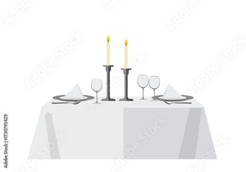 Table setting with plates wine glasses candles and a white tablecloth