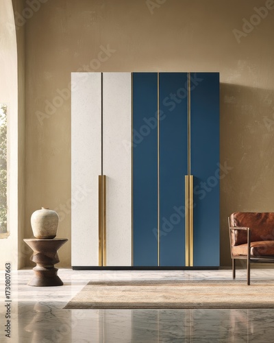 A modern wardrobe with a contemporary design, featuring contrasting white and navy blue panels, accentuated by brass handles, sits in a sophisticated, neutral-toned room.