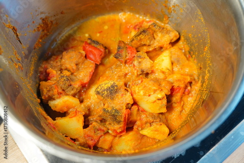 Quadro su tela Close-up view of a savory, spiced stew with chunks of meat and vegetables simmer