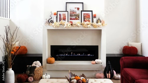 Cozy autumn decor display in a beautiful warm modern living room with fireplace burning