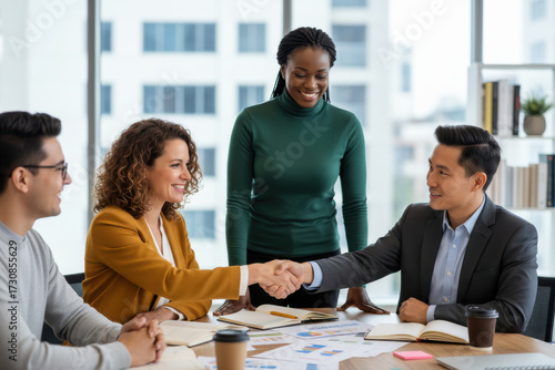 A group of people sitting around a table shaking hands