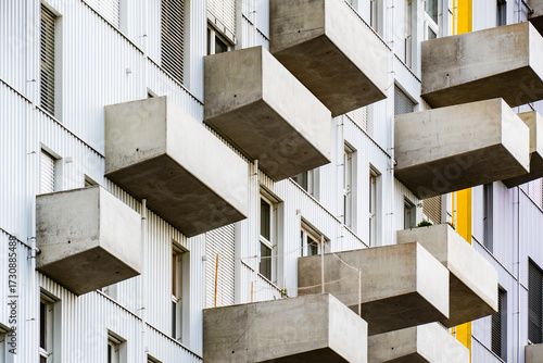 Modern residential building with projecting concrete balconies and minimalist geometric design emphasizing urban architectural rhythm