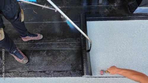 Roofer applying torch to bitumen membrane on torch down roof