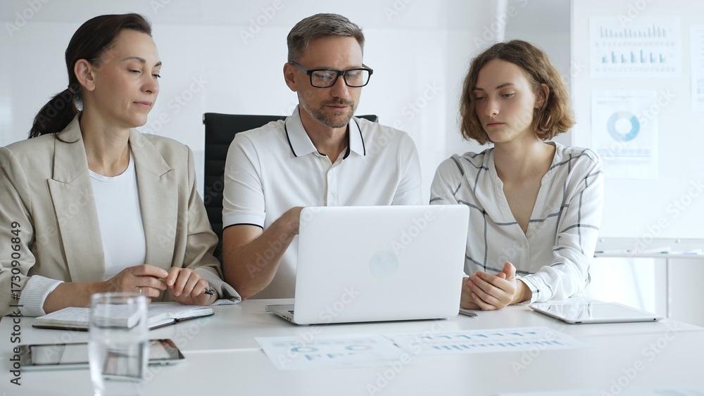 Obraz premium Business people team collaborating on a project, analyzing data on a laptop during a productive office meeting, demonstrating teamwork and problem solving skills