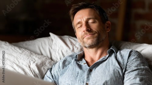 Man resting peacefully on a cozy couch in a relaxed setting during evening hours