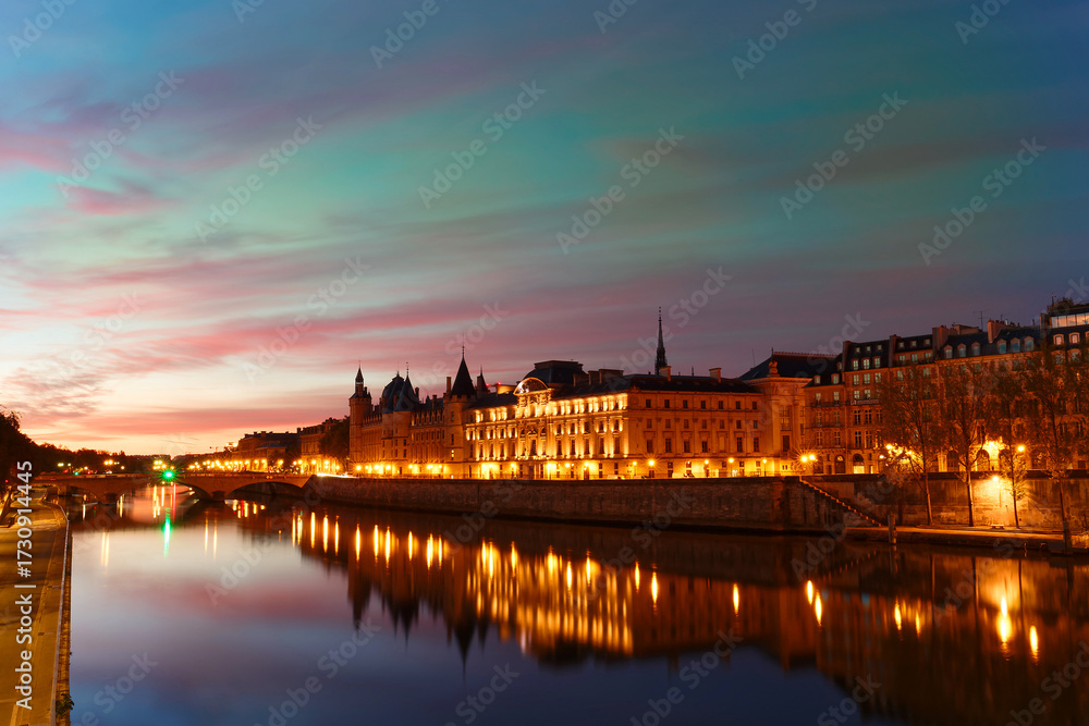 Fototapeta premium Conciergerie building located along of the Seine river and the center of Paris under a early sunrise lights. It was successively King's palace the prison and justice hall in French history.