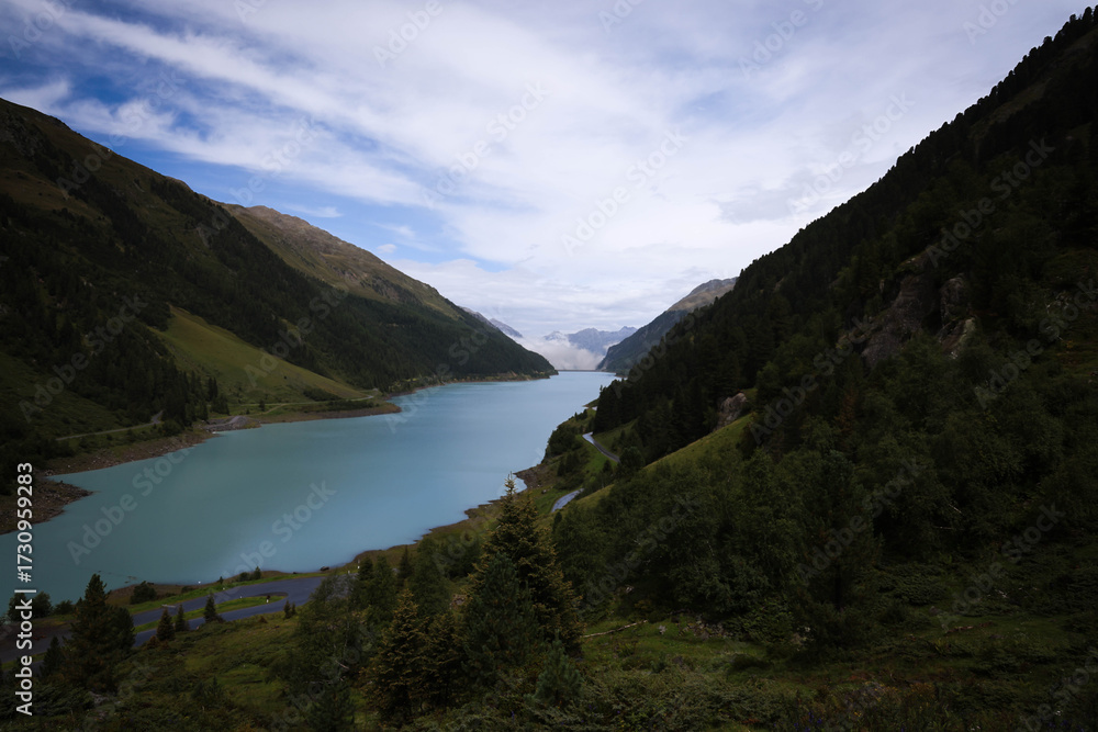 Fototapeta premium Austrian Alps mountain with lake, clouds, and grazing cows / Montaña de los Alpes austriacos con lago, nubes y vacas pastando / Österreichischer Alpenberg mit See