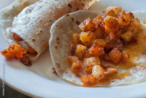 Potato and chorizo tacos, in flour tortillas on a white plate, typical breakfast of northwest Mexico