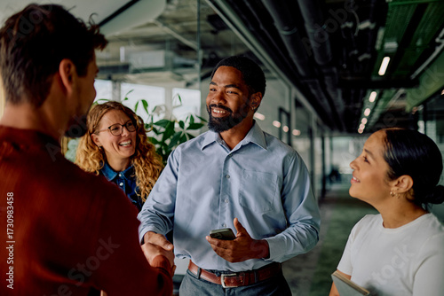 фотографія Diverse business team collaborating and shaking hands in an office hallway, fost
