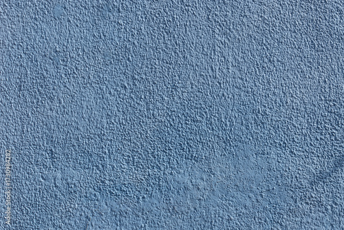 Detalle frontal de muro mexicano pintado de color azul sucio vibrante, textura. Concreto decorado con acabado rustico y cacarizo. Pared antigua tradicional con diseño de la epoca colonial.