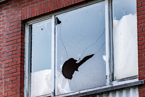 Damaged window glass after vandalism incident shows need for repair and security following a break in at a home or business, conveying vulnerability and property crime
