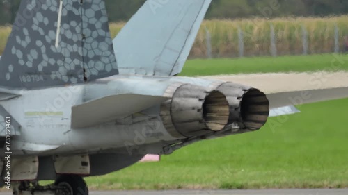 F-18 fighter jet preparing for takeoff at airfield on a sunny day