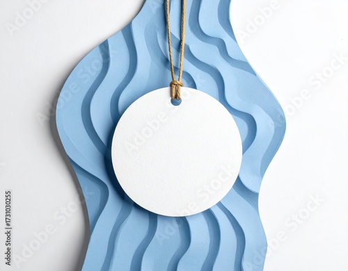 Round tag on string against wavy blue paper