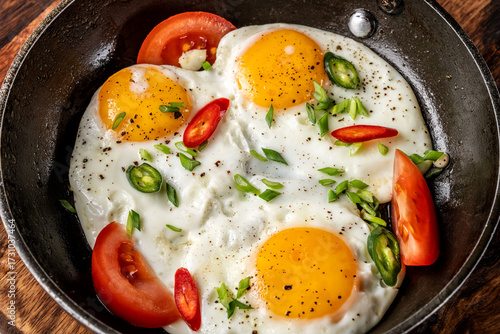Obraz na płótnie Sunny side up eggs with tomatoes and chili