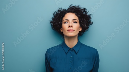 Confident Woman with Curly Hair Against a Blue Background