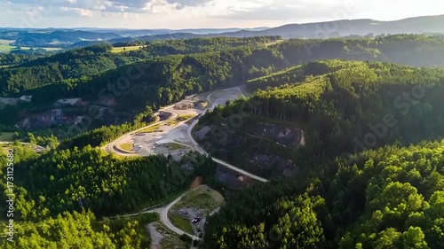 Aerial view of lush green hills and winding roads in a natural landscape