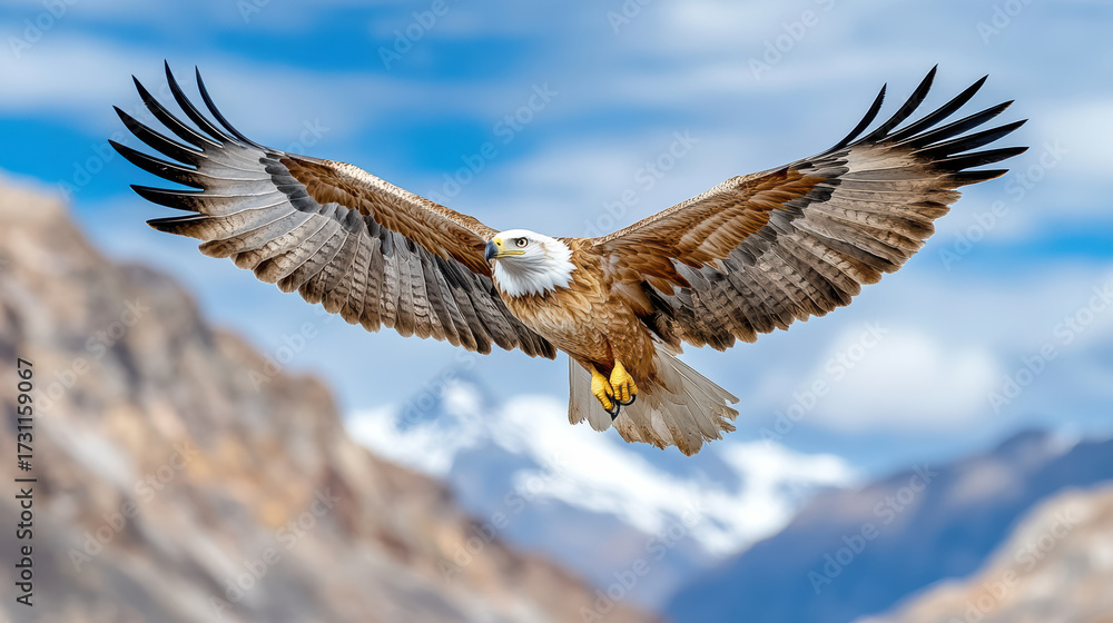 Fototapeta premium Majestic eagle soaring above mountain peaks with wings fully extended, showcasing its power
