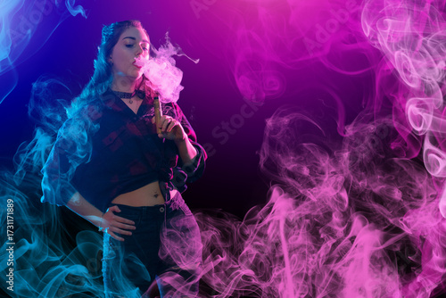 Young woman exhaling vapor ...