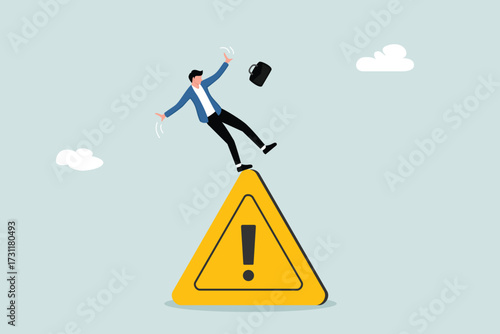 The concept of business risk, warning of problems and avoiding danger. An entrepreneur slips and falls on a warning sign.