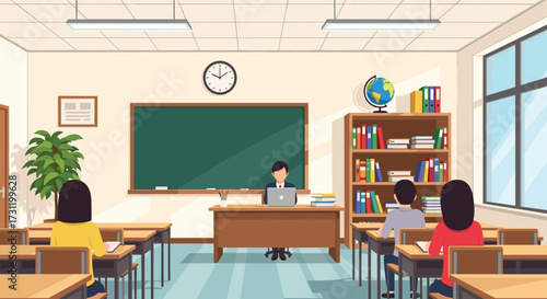A teacher stands at the front of a classroom instructing students at their desks.